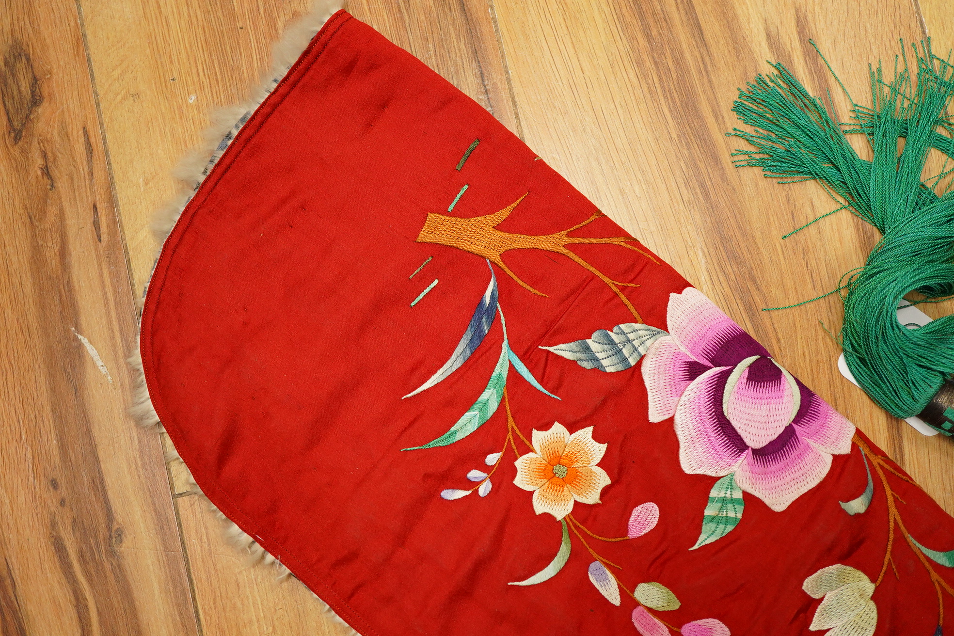 A 20th century possibly Miao, child’s multi coloured silk embroidered and padded winter hood, with fur trim and ornate tasselled decoration, 54cm long. Condition - the light green silk edge has worn and has lightly disco